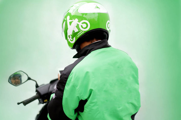 вид сзади на мотоцикл с помощью однородного такси gojek онлайн. yogyakarta Индонезия. 30 марта 2020 - Фото, изображение