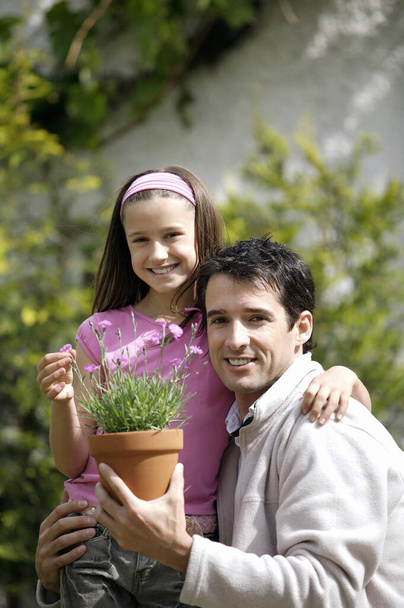 Man and girl with a pot of flowers - Φωτογραφία, εικόνα