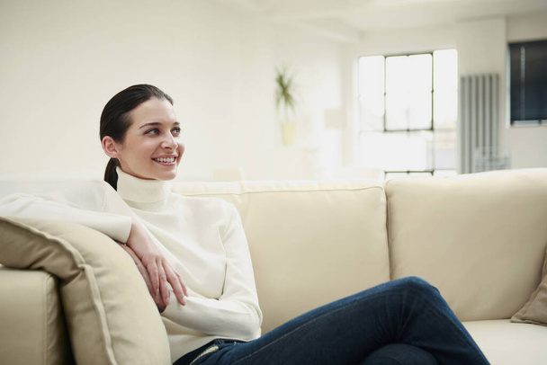 Smiling woman sitting on couch - Photo, Image