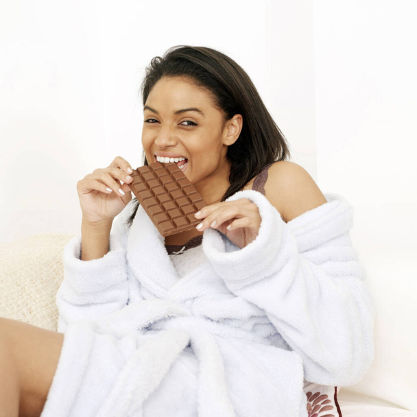 Woman in bathrobe enjoying a bar of chocolate - Foto, immagini