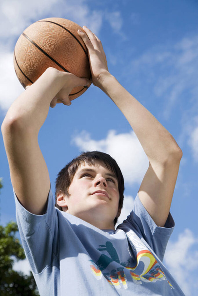 Boy about to throw basketball - Фото, зображення
