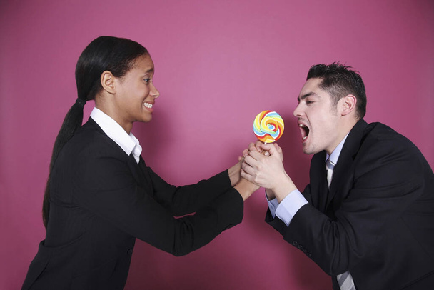 Businessman grabbing lollipop from businesswoman - Foto, immagini