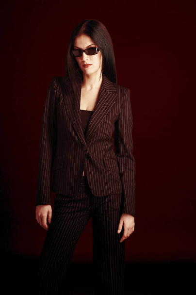 Studio shot of a lady in office attire wearing a sunglass - Фото, изображение