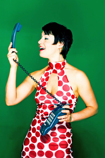 Woman in red and white polka dots dress talking on the phone - Photo, Image
