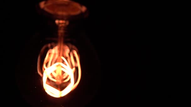 Slow camera movement in macro reveal sharp details in part of Tungsten light bulb or Edison bulb. Cozy view over black background, macro close up shot of old retro vintage light. 4k. - Metraje, vídeo