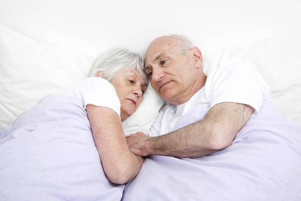 Senior man and woman contemplating while sleeping together - Fotoğraf, Görsel