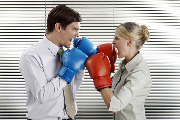 Businessman and businesswoman with boxing gloves facing each other - Photo, Image