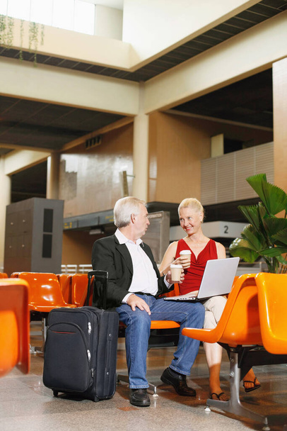 Businessman and businesswoman enjoying coffee in airport lounge - Photo, image