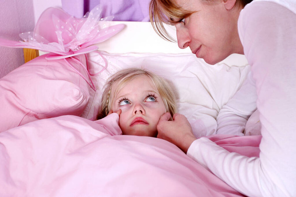 A woman comforting her terrified daughter - 写真・画像