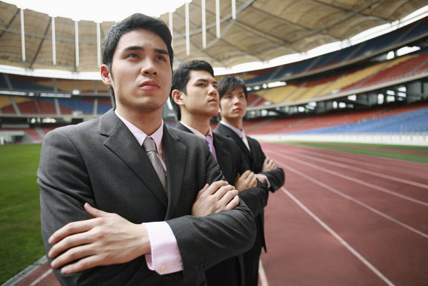 Business people standing in a row on running track - Foto, imagen