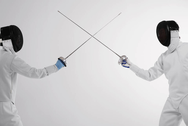 Two men in fencing suits in a duel - Fotó, kép