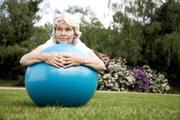 Femme âgée reposant sur le ballon de fitness - Photo, image