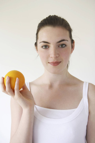 portrait of Woman holding orange - Foto, Imagen