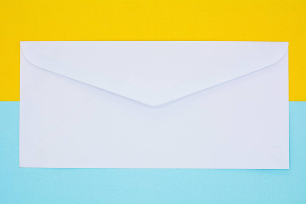 envelope branco correio no fundo amarelo e azul
 - Foto, Imagem