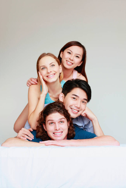 Friends posing on top of each other on the bed - Фото, изображение