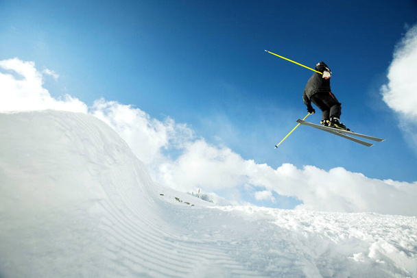 Man doing a mid air ski jump off a mountain - Foto, immagini