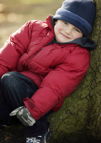 Portrait of a boy leaning on a tree - Fotoğraf, Görsel