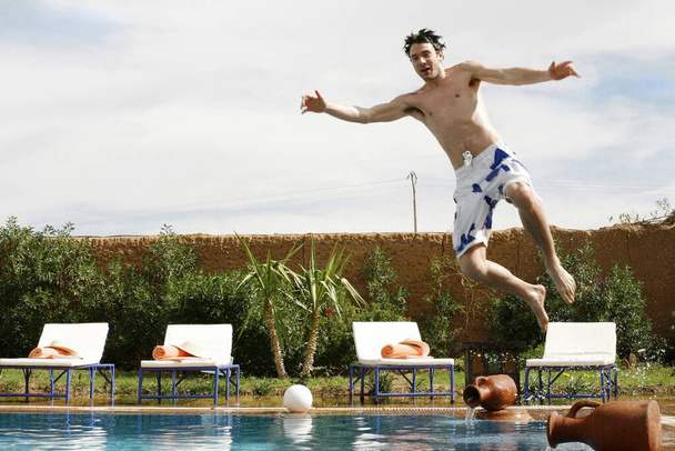 Мужчина прыгает в бассейн
 - Фото, изображение
