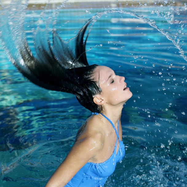 Woman emerging from under the water splashing her hair - Foto, immagini