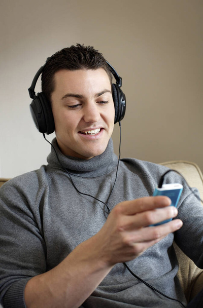 Man listening to music on portable MP3 player - Foto, afbeelding