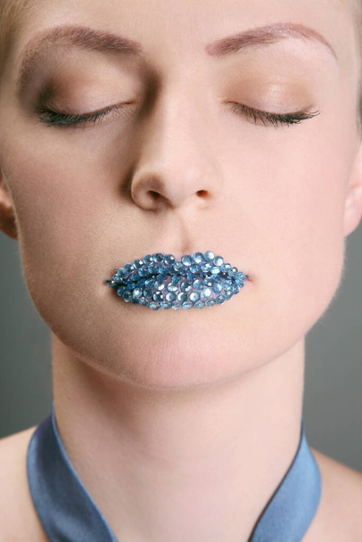 Woman with rhinestones on her lips closing her eyes - Valokuva, kuva