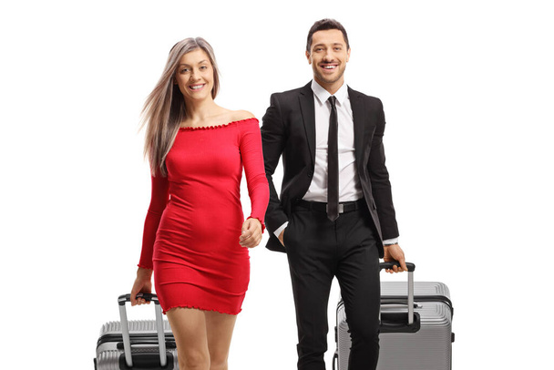 Elegant woman and man with suitcases walking towards the camera isolated on white background - Foto, Bild
