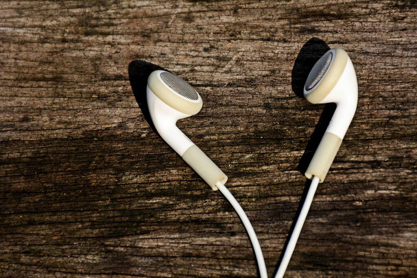 białe słuchawki na starym tle drewna - Zdjęcie, obraz