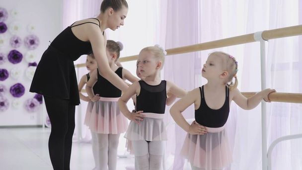 Ryhmä pikkutyttöjä oppimassa uusia tanssiliikkeitä balettitunnin aikana - Valokuva, kuva