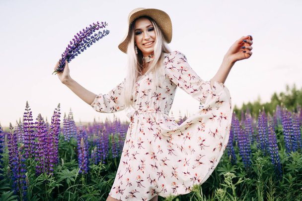 blonde girl holding a lupine photo in motion. - Photo, Image