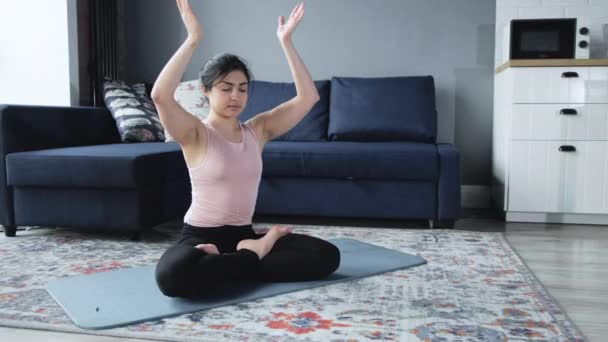 Умиротворена жінка-індіана медитує в позі лотоса. Розслаблена жінка практикує вправи з йоги сидячи на підлозі в східному інтер "єрі.. - Кадри, відео