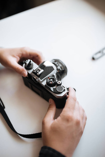 Vintage Pentax film camera in the hands of a man on a white background. Vertical - Fotoğraf, Görsel