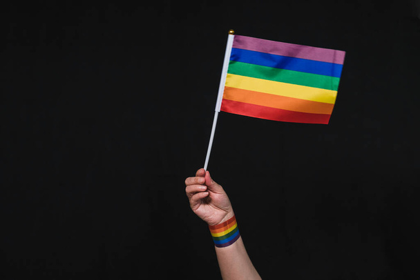 Arma de la bandera arco iris del orgullo gay. Levanta el brazo con la bandera del orgullo gay. Orgullo. Bandera del arco iris. Banner de orgullo gay
. - Foto, Imagen