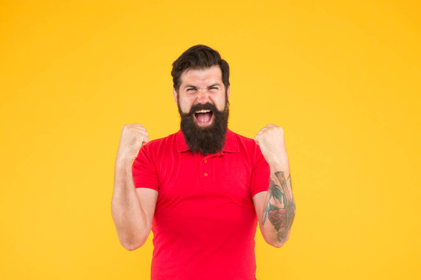 Celebrating triumph. Happy man show yes gesture yellow background. Victory and success. Hipster look of brutal man. Barbershop. Bearded man in casual style. Menswear store. Make man look his best - Foto, afbeelding
