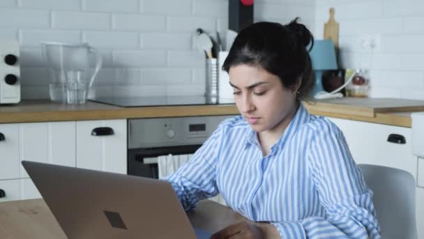 Nuori nainen, joka käyttää kannettavan tietokoneen kirjoitusmuistiinpanoja, seisoo kotitoimiston pöydällä, liikenainen ammattimainen työ tietokoneen suunnitteluohjelmassa henkilökohtaisen suunnittelijan ja online-kalenterin kanssa. - Materiaali, video