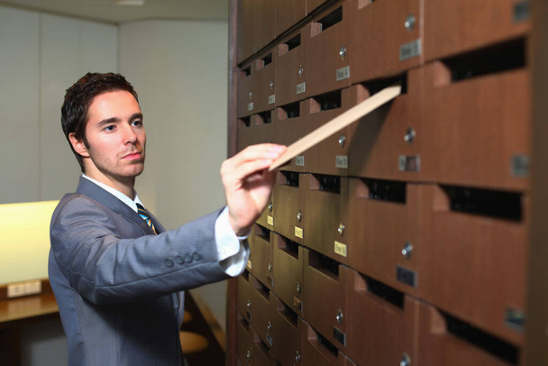 Businessman putting letter into mailbox - Foto, Imagen