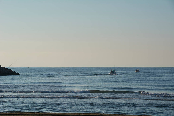 Beach with fishermen boats, spikes, sunrise, sunny - Photo, Image