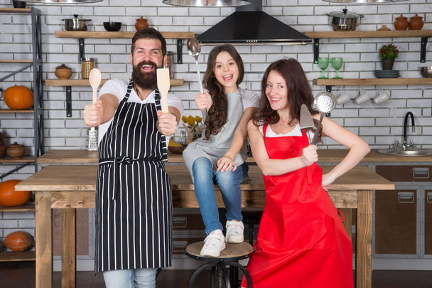 love and support. healthy food concept. professional chef team. happy childhood. happy family day. father and mother with daughter cook in kitchen. little girl cooking with parents. Too busy - 写真・画像