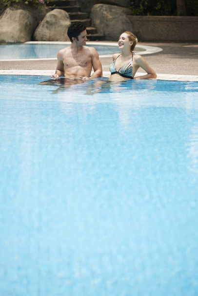 Man and woman relaxing in pool - Фото, изображение