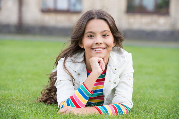 in good mood. back to school. Small girl wear casual clothes. beauty and fashion. beautiful student teen girl in park. cute smiling confident schoolgirl relax on green grass. happy childhood - Foto, imagen