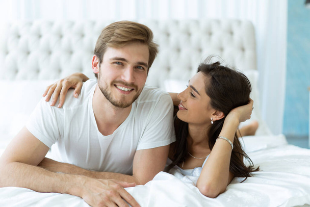Young happy couple lying together in bed. - Photo, image