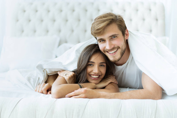 Young happy couple lying together in bed. - Foto, Bild