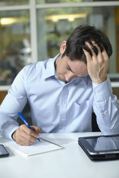 Businessman concentrating while writing - Фото, зображення
