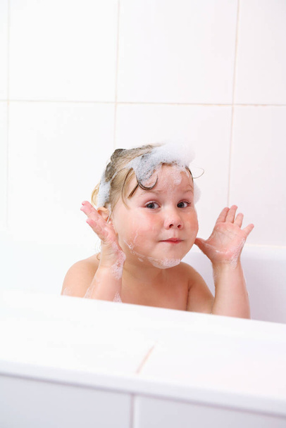 Girl making funny faces in the bathtub - Фото, зображення