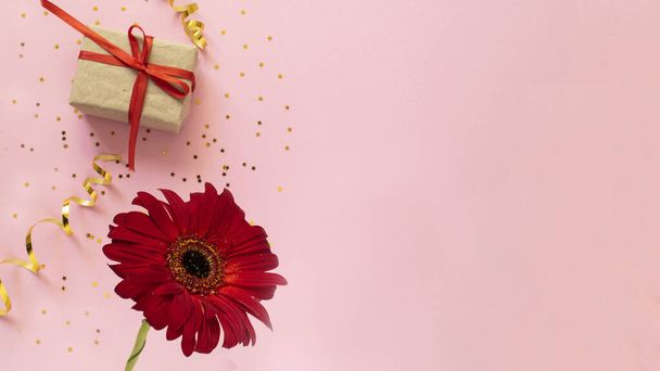 Beautiful red gerbera flower and gift box on pink background. Happy Mother's Day, Women's Day, Valentine's Day or Birthday greeting card. celebration greeting concept, flat lay and copy space - Foto, Imagen
