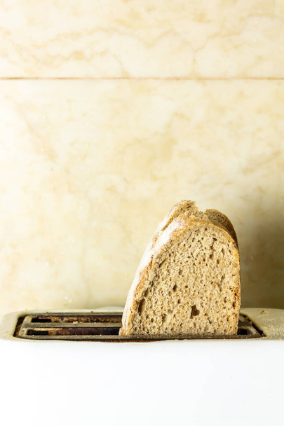 Ψήνω φέτες ψωμιού για να κάνω τοστ το πρωί. Έννοια του πρωινού και ισορροπημένο γεύμα και διατροφή. - Φωτογραφία, εικόνα