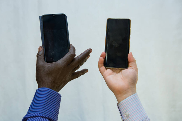Black lives matter. Afroamerican and european hands holding phones close together. - Photo, Image