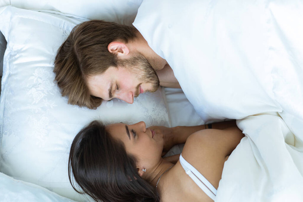 Close-up of happy couple is lying in bed together. Enjoying the company of each other. - Foto, Bild