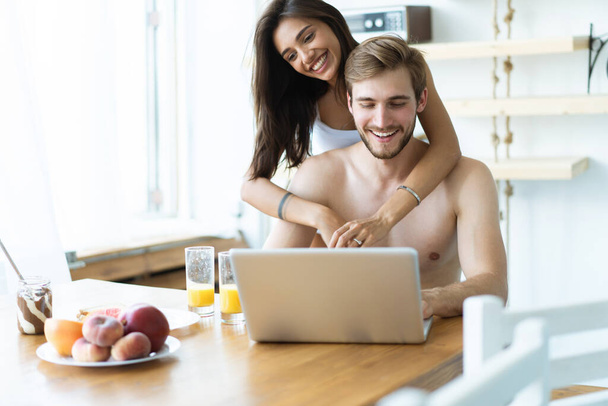 Couple in front laptop computer in the kitchen. - Photo, Image
