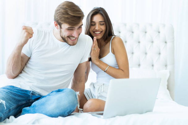 Young couple with laptop in the bed in room. - Foto, immagini