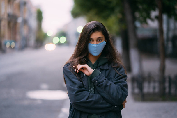 Mladá žena, osoba v ochranné lékařské sterilní masce na prázdné ulici - Fotografie, Obrázek
